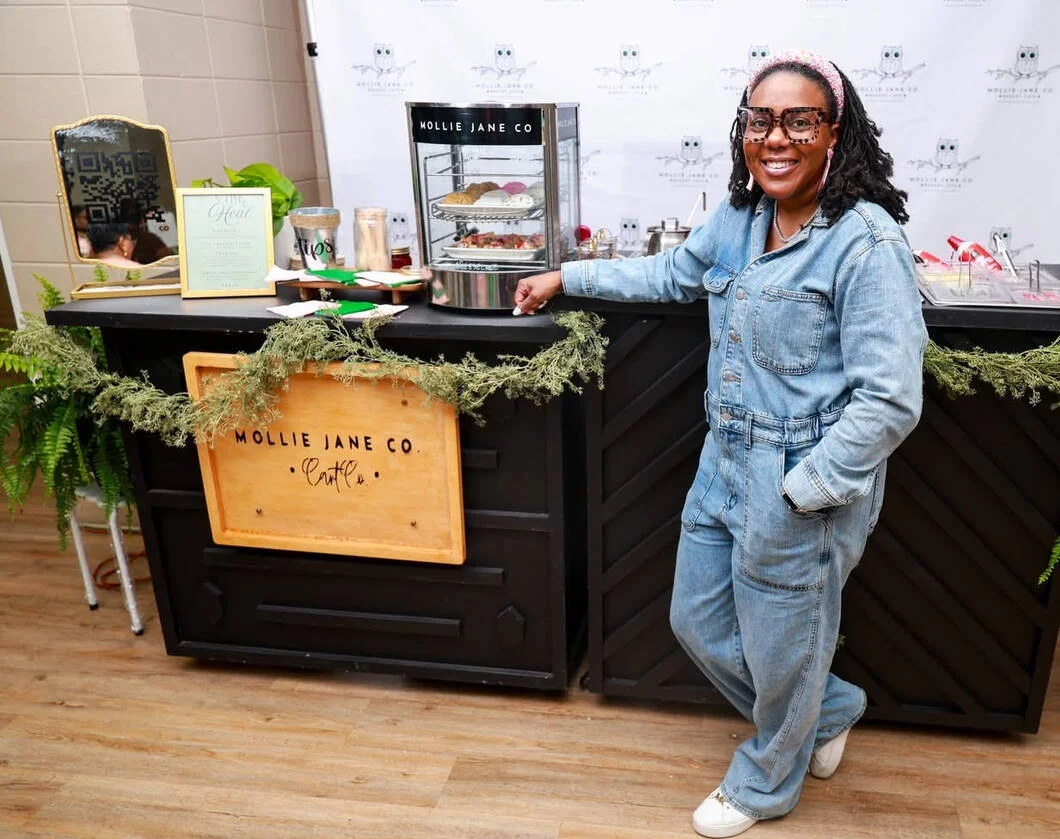 Sandra Plainer-Molden standing beside a Mollie Jane Co. dessert display in Pascagoula