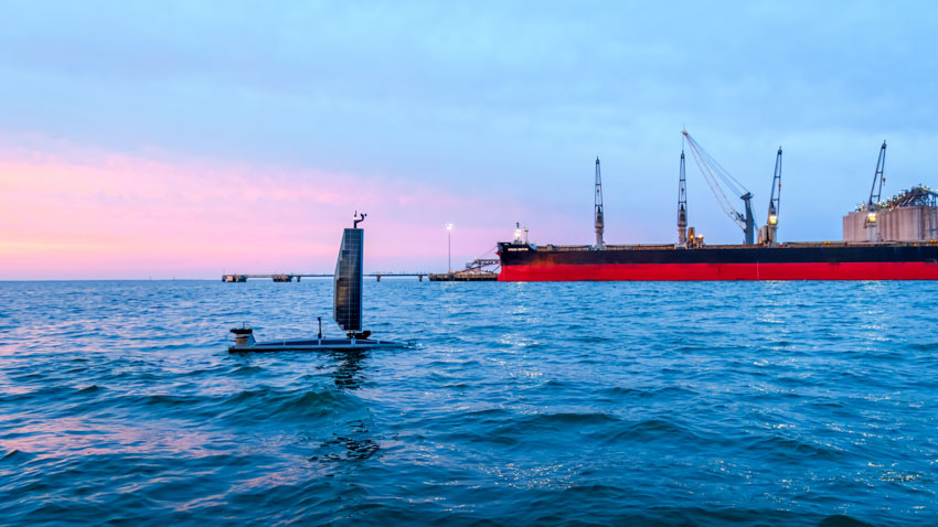 Ocean Aero TRITON autonomous vessel sailing near a cargo ship at the Port of Gulfport